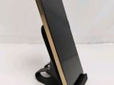 a close up of a cell phone on a stand on a white surface