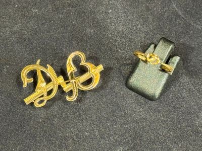two pieces of jewelry that are laying on a table