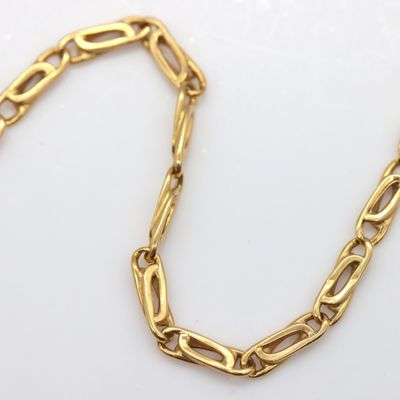 a close up of a gold chain on a white surface