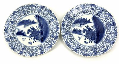 pair of blue and white plates with figures on them