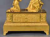 a gold statue of two women sitting on a bench