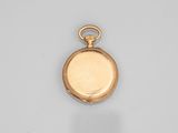a close up of a gold pocket watch on a white surface