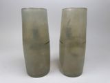 two tall vases sitting next to each other on a table