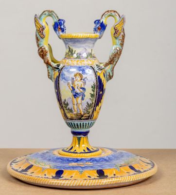 un vase bleu et jaune posé sur un socle, sur une table