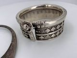 a silver ring sitting next to a pair of scissors on a table