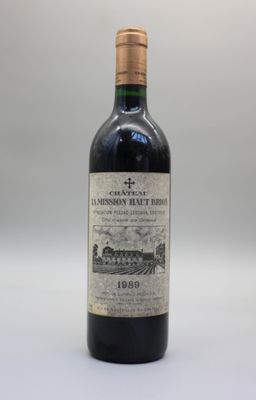 une bouteille de vin rouge posée sur une table blanche