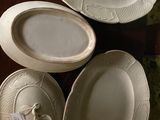 three white dishes sitting on top of a wooden table next to each other