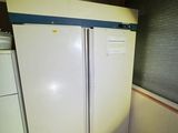 two white refrigerators in the corner of a kitchen