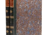 un vieux livre à la couverture bleue et marron posé sur une surface blanche