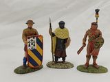 three figurines of men dressed in medieval clothing and holding shields
