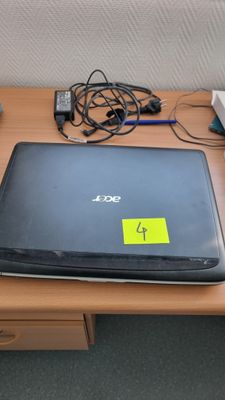 a laptop computer sitting on a desk with a yellow sticker on it