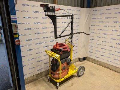 a yellow cart with a hose on it in front of a wall