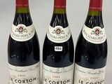 three bottles of red wine are lined up on a table