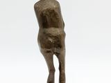 bronze statue of a woman standing on a base with her back to the camera