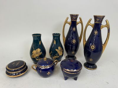 several pieces of blue and gold vases and lids on a white surface