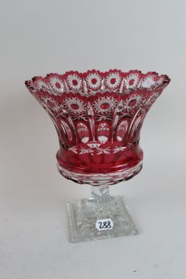 a red glass bowl on a clear stand