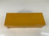 an old yellow box sitting on top of a white table