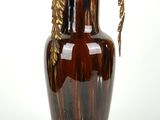 a brown vase with a gold handle on a white background