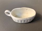 a small white bowl with a handle on a table