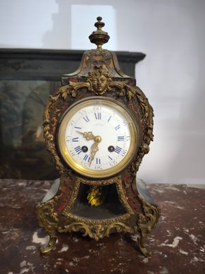a clock that is sitting on a table in front of a fireplace