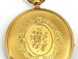 an image of a gold pocket watch with a floral design on it