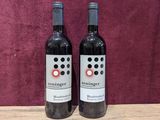 two bottles of wine sitting on top of a wooden table