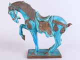 une statue bleue représentant un cheval avec une selle sur le dos