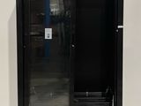 an image of a black refrigerator in a warehouse