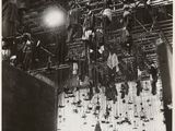an old black and white photo of a bunch of clothes hanging from a ceiling