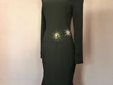 une robe noire avec des détails dorés sur les épaules et les épaules
