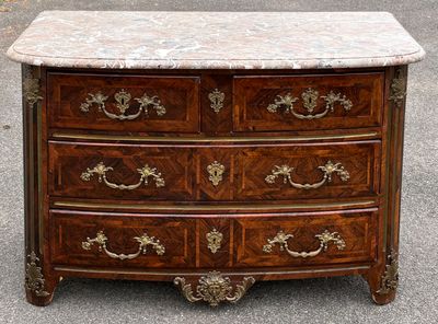 une commode au plateau en marbre exposée dans un parking