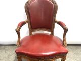 an image of a red leather chair sitting on top of a stone floor