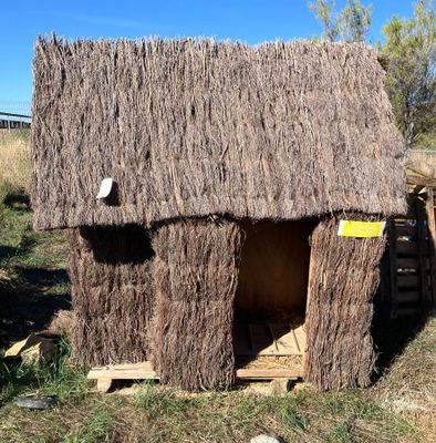 une petite cabane faite de brindilles, dans l'herbe