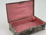 a silver box with a pink lining on the inside