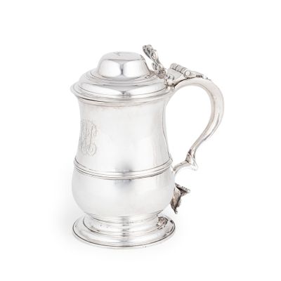 une chope ancienne en métal argenté, munie d'une anse en corde, sur fond blanc
