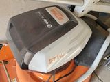 an orange and white lawn mower sitting on top of a brick floor