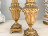 two gold vases sitting on a marble table