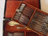 a wooden case with silverware in it on a white surface