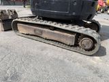 an image of a black and gray construction vehicle parked in a parking lot