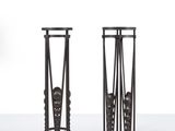 pair of black iron candlesticks with a man ' s head on the top