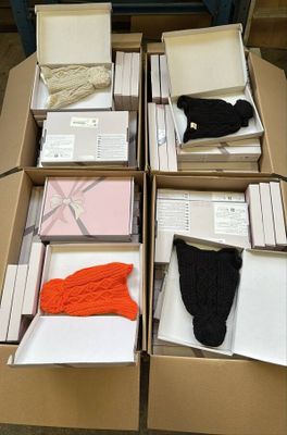 Plusieurs cartons de vêtements sont empilés les uns sur les autres sur une table