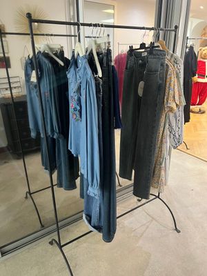 beaucoup de vêtements suspendus à une étagère dans un magasin