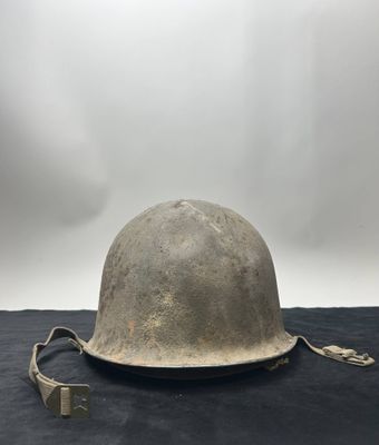 an old helmet is sitting on top of a black cloth