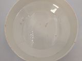 a white bowl on a table with a white background