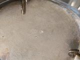a close up of a metal pan with a bird on it