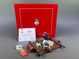 figurines of a man on a boat with a dog and a sign