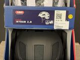 Deux cartons de casques sont empilés l'un sur l'autre sur une table