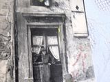 une vieille photo d'une femme debout devant un immeuble