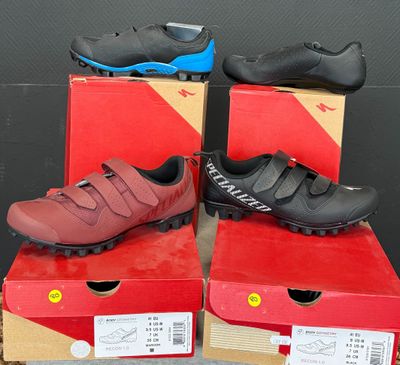 Trois paires de chaussures de VTT sont exposées dans une boîte
