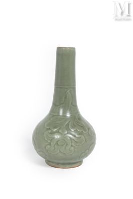 un vase vert posé sur une surface blanche